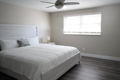 1 dormitorio blanco con 1 cama y ventilador de techo en Hosting new, en Tampa