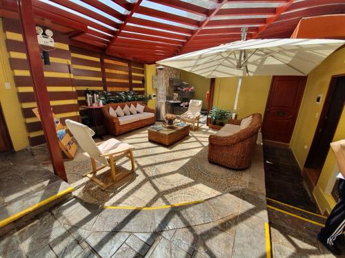 a living room with chairs and an umbrella at El Mariscal Cusco in Cusco
