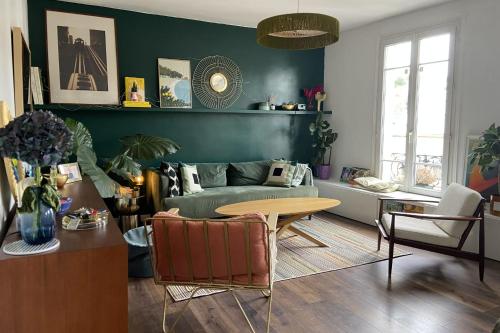 een woonkamer met een bank en een tafel bij Spacious 70 m renovated duplex family home in Suresnes