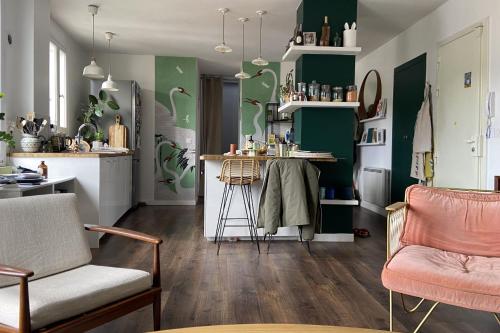 een woonkamer met groene muren en een keuken bij Spacious 70 m renovated duplex family home in Suresnes