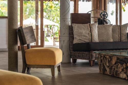 a living room with a chair and a table at Moorea Island Beach Hotel in Moorea