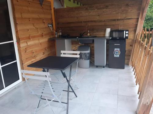 a patio with a table and chairs and a counter at Zabriko delair in Sainte-Anne