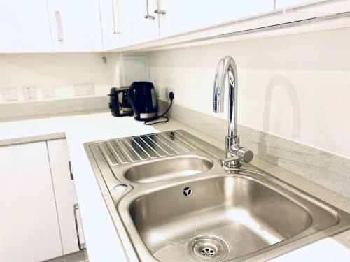 a stainless steel sink in a white kitchen at NEW - Chic 2-Bedroom Apartment with Parking - DA8 in Erith