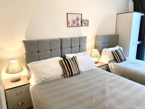 a bedroom with a large bed with pillows on it at NEW - Chic 2-Bedroom Apartment with Parking - DA8 in Erith