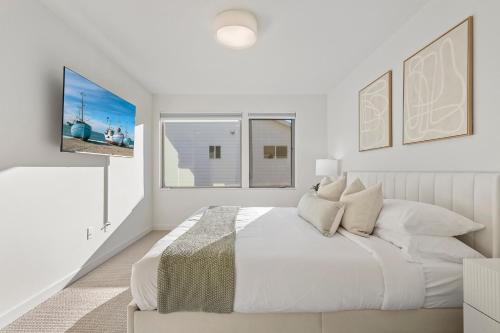 a white bedroom with a bed and two windows at New Meridian Park Shoreline WA in Shoreline