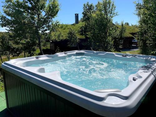 a jacuzzi tub sitting on top of a patio at Bjørnebuhytten, Geilo, 13 sengeplasser med privat Jacuzzi og el-bil-lading in Geilo