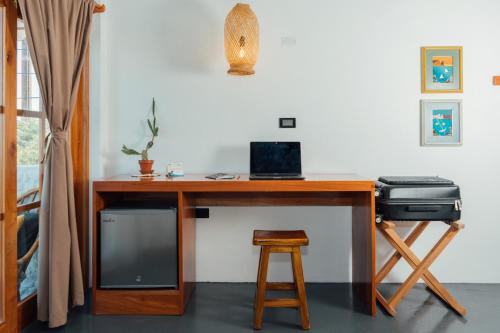 a wooden desk with a computer and a stool at Hotel Pimampiro in Puerto Baquerizo Moreno
