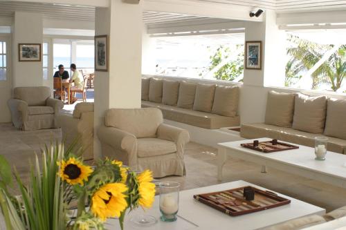 
a living room filled with furniture and flowers at Coral Sands Hotel in Harbour Island
