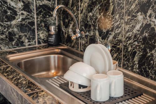 a kitchen sink with a toilet sitting on a drying rack at Hotel Pimampiro in Puerto Baquerizo Moreno