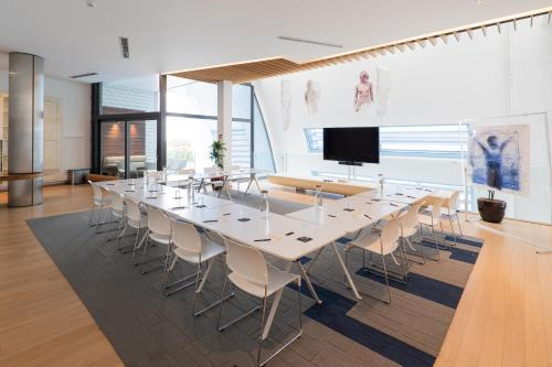 a large conference room with a long table and chairs at voco Brussels City North by IHG in Vilvoorde