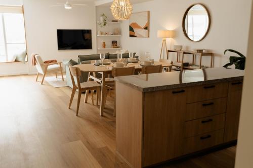 una cucina e una sala da pranzo con tavolo e sedie di Vida Central - 2 bed, 1.5 bath w parking, gym & pool a Newcastle