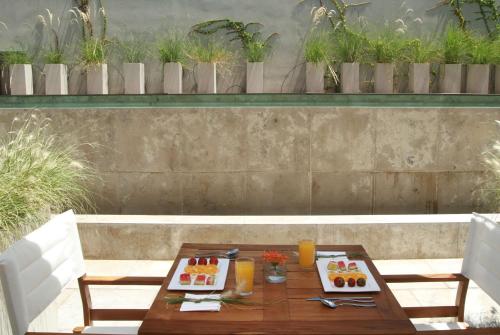a wooden table with two plates of food on it at Dazzler by Wyndham Buenos Aires Palermo in Buenos Aires