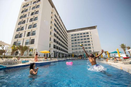 two people playing in the swimming pool at a hotel at Rove La Mer Beach, Jumeirah in Dubai