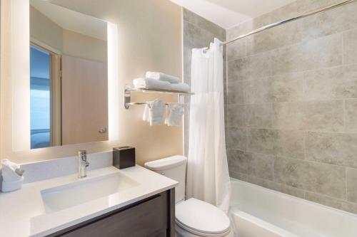 a bathroom with a sink and a toilet and a mirror at Best Western Glenview - Chicagoland Inn and Suites in Glenview