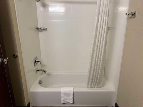 El baño incluye bañera blanca con cortina de ducha. en Best Western Columbia River Waterfront Hotel Astoria, en Astoria, Oregon