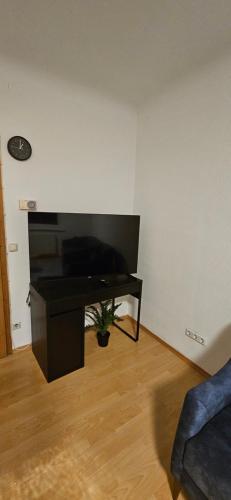 een woonkamer met een televisie en een tafel bij Omega Suite 6 min to Center in Wenen