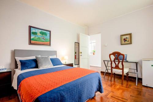 Charming Miraflores Guesthouse with Terrace Studio Apartment and Private Room في ليما: غرفة نوم بها سرير ومكتب وكرسي