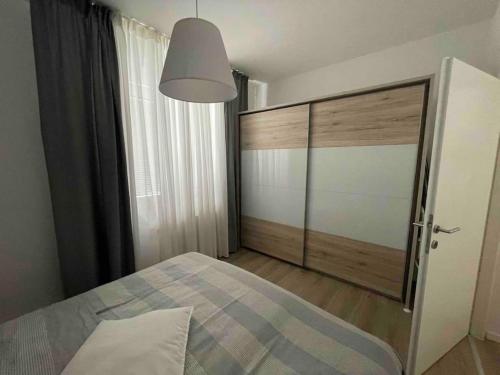 sypialnia z łóżkiem i dużymi przesuwnymi drzwiami w obiekcie Apartman III u centru Kutine w mieście Kutina