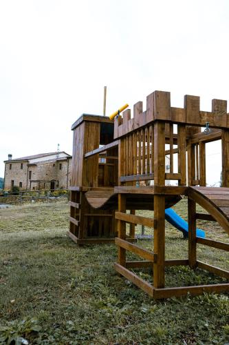a wooden playground with a slide in a field at Agriturismo Fonte Belvedere in Collesalvetti