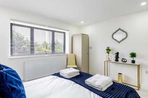 twee bedden in een kamer met een raam bij 4bed large modern near elizabeth line west london flat free parking in Londen