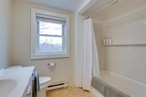a bathroom with a toilet and a sink and a window at Expansive Wilmot Escape with Deck Near Skiing! in Wilmot