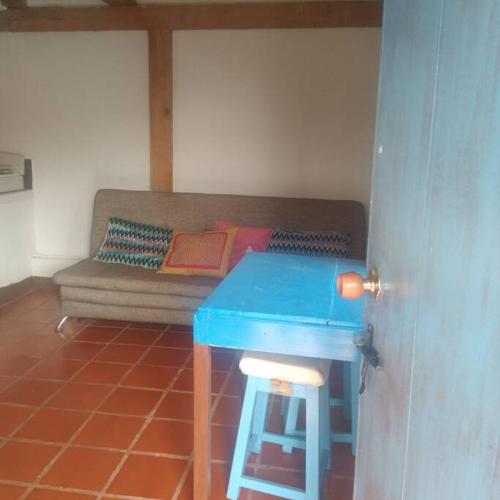 a room with a couch and a blue table and stool at Apartamento campestre in Villa de Leyva