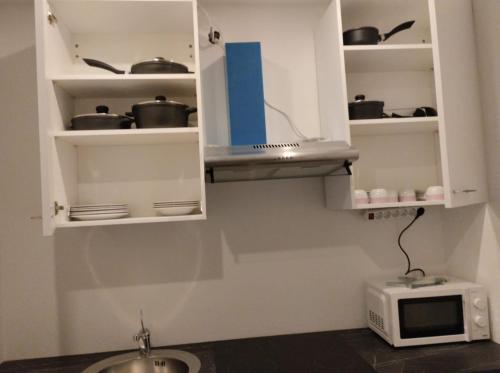 Una cocina con gabinetes blancos y un microondas. en Mozarts Salzburg City Retreat, en Salzburgo