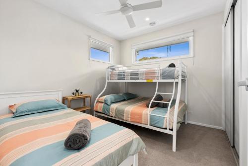 1 Schlafzimmer mit 2 Etagenbetten und einem Fenster in der Unterkunft Field By The Beach in Ocean Grove