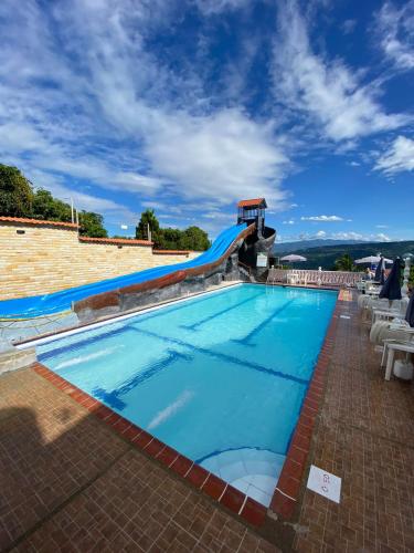 a swimming pool with a slide in a resort at Hotel Piscina Macaliz in Subía