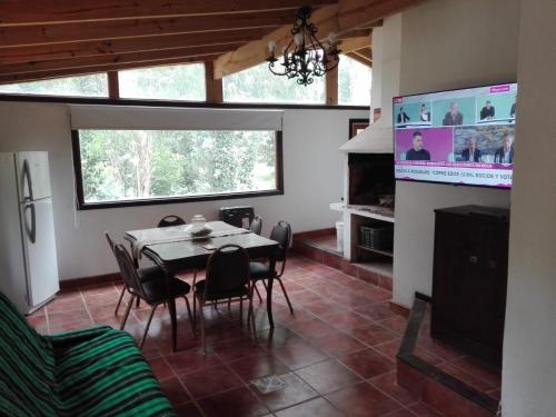 ein Esszimmer mit einem Tisch und Stühlen sowie einem TV in der Unterkunft Casa del Bosque in Mar del Plata