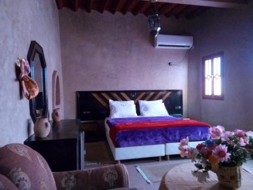 a bedroom with a bed and a guitar in a room at RIYAD ZENAGA in Figuiq