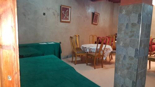 a room with a table and chairs and a table and a dining room at RIYAD ZENAGA in Figuiq