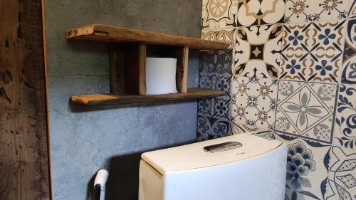 a bathroom with a toilet and a shelf on the wall at Little House in KhauPha 