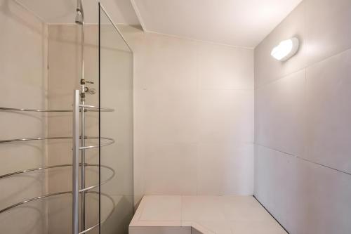 uma cabina de duche em vidro numa casa de banho com paredes brancas em Cyclinn Faria Lima Itaim em São Paulo