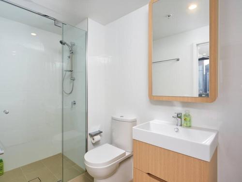 a bathroom with a toilet and a sink and a shower at Artistic South Brisbane 2 bedroom Apartment with Parking in Brisbane