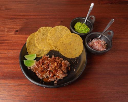 a plate of food with tacos and salsa on a table at Trinitarios in Barichara