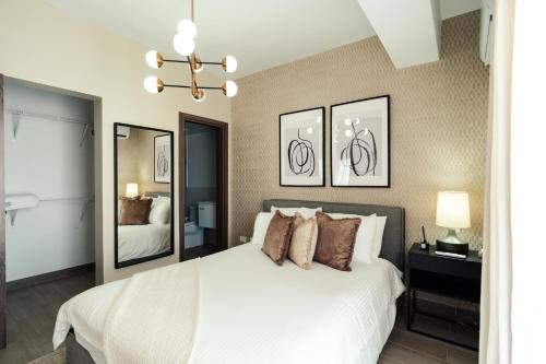 1 dormitorio con cama blanca y espejo en Luxury 2Bedr, 2 Balcony Pool, Gym, Downtown Santo Domingo, en Santo Domingo