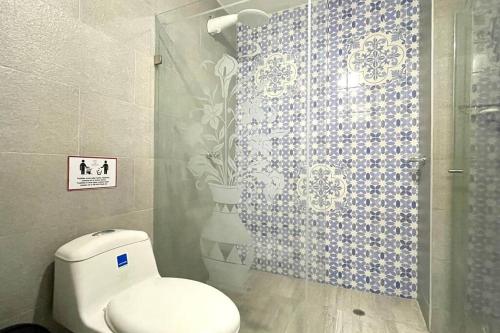 uma casa de banho com um WC e uma cabina de duche em vidro. em Gorgeous 8 BR House w/ Pool in the Old City em Cartagena das Índias