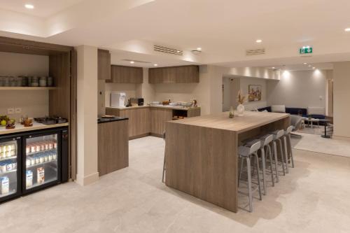 a kitchen with a large island with bar stools at Staybridge Suites - Cannes Centre by IHG in Cannes