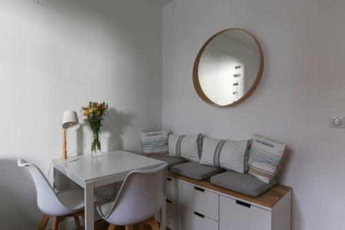 een tafel en stoelen en een spiegel in de kamer bij Comfortable and well-appointed 30 m apartment in Vanves