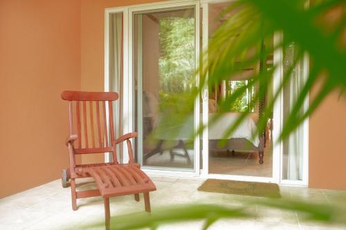 a wooden rocking chair sitting in front of a door at Secluded Garden Paradise Condo @Los Sueños in Herradura