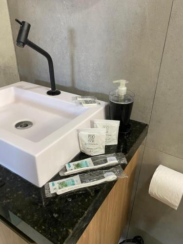 a bathroom counter with a sink and toothbrushes at Edifício Creta in São Luís