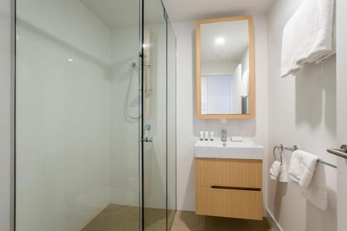 La salle de bains est pourvue d'une douche en verre et d'un lavabo. dans l'établissement Inner-city 1 bedroom Apartment Parking and Pool, à Brisbane