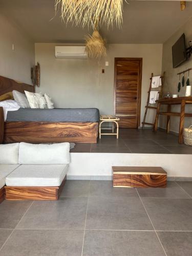 a bedroom with a bed and a couch in it at Mare mío Hotel Boutique in Puerto Arista