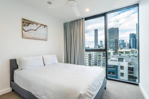 - une chambre avec un lit blanc et une grande fenêtre dans l'établissement Inner-city 1 bedroom Apartment Parking and Pool, à Brisbane