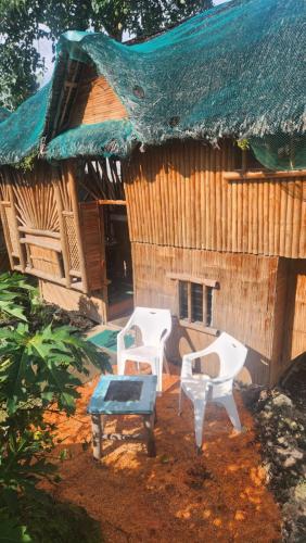 eine Gruppe von Stühlen, die vor einem Haus sitzen in der Unterkunft Nirvana Bamboo & Dive resort in Moalboal