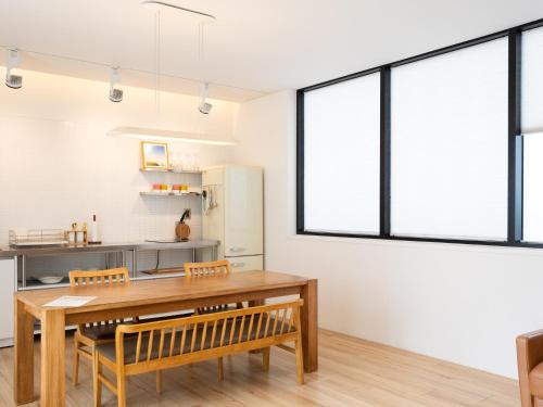 a kitchen with a wooden table and some windows at Boutique Pool Villa NAMIB in Jeju