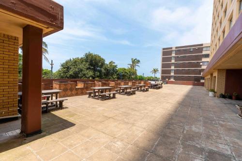a row of tables and benches on a patio at Amanzi402 Oceanview Retreat in Amanzimtoti