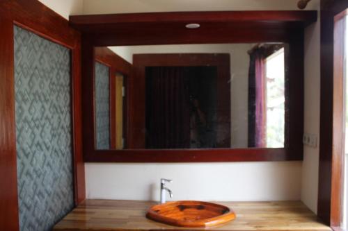 a bathroom with a wooden sink and a mirror at Gili Tempoe in Gili Trawangan