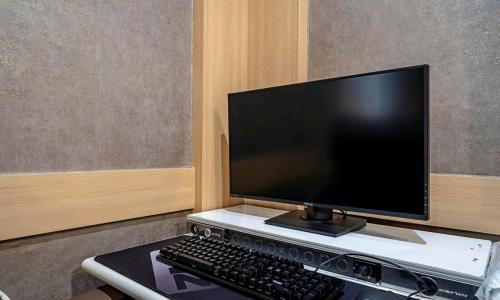 a computer monitor and a keyboard on a desk at 충주 호텔 발리 in Chungju